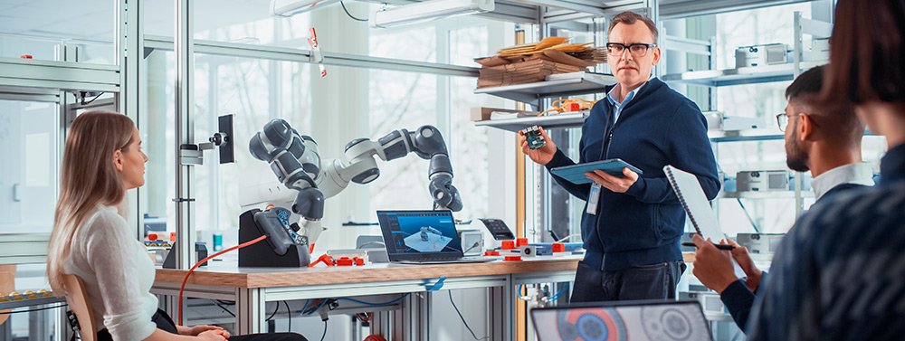inteligencia_artificial_kit_consulting Grupo de personas reunidas entorno a un brazo robótico. Servicio de Inteligencia Artificial Kit Consulting